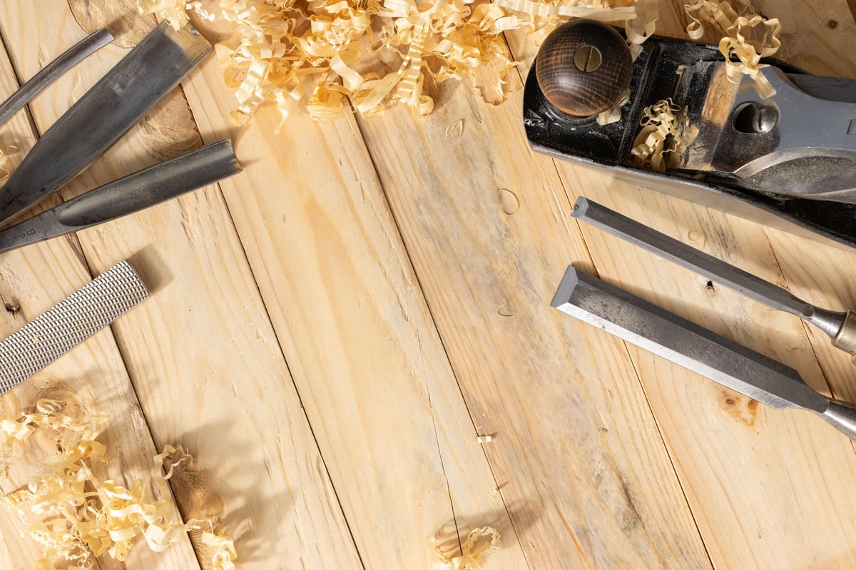 Top view of a traditional carpenter tools and wood shavings on wooden background with Copy space